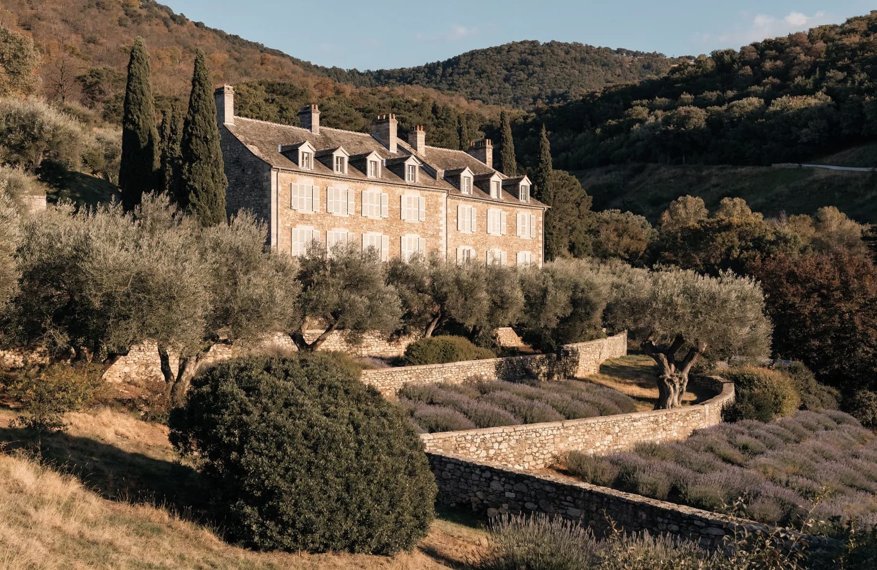 Restored Provençal stone bastide with pale shutters among olive terraces, lavender and cypress in the Côte d'Azur hinterland