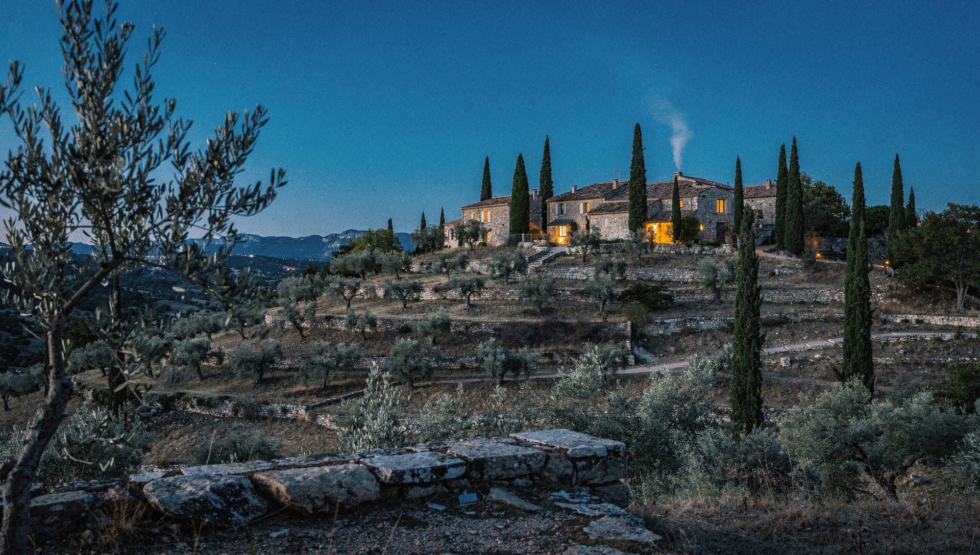 Wide view over the Grasse hinterland valley with stone villages and olive terraces under early morning Riviera light